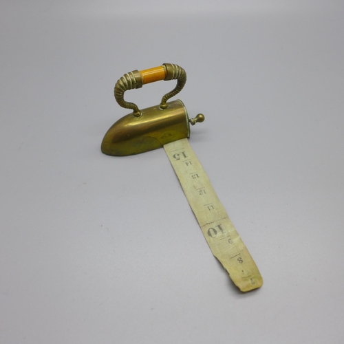 896 - An early 20th Century novelty tape measure in the form of an iron