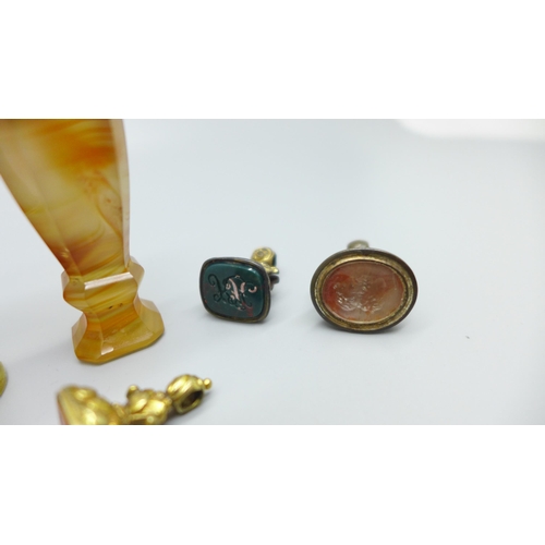 920 - An agate seal, a brass seal with swan finial and three seal fobs