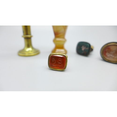 920 - An agate seal, a brass seal with swan finial and three seal fobs