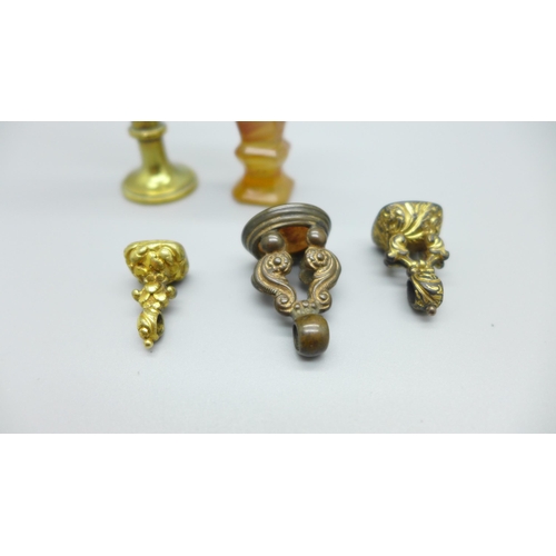 920 - An agate seal, a brass seal with swan finial and three seal fobs