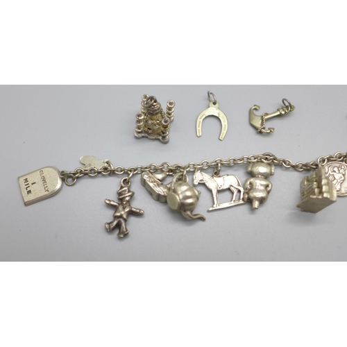 963 - A collection of white metal and silver charms on a chain