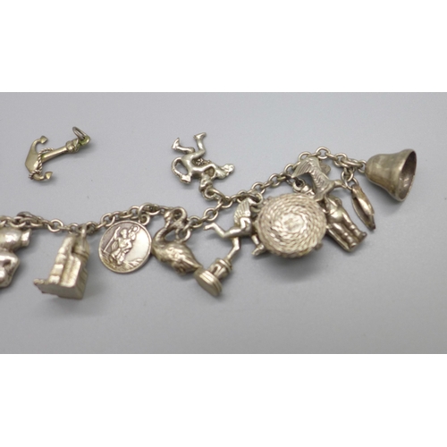 963 - A collection of white metal and silver charms on a chain