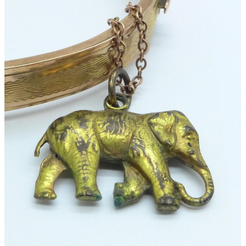 967 - A 9ct gold bangle, 8.7g, with a plated elephant charm