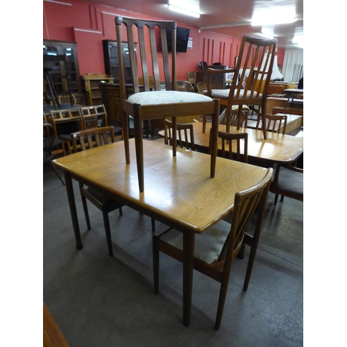 137 - A teak extending dining table and three chairs