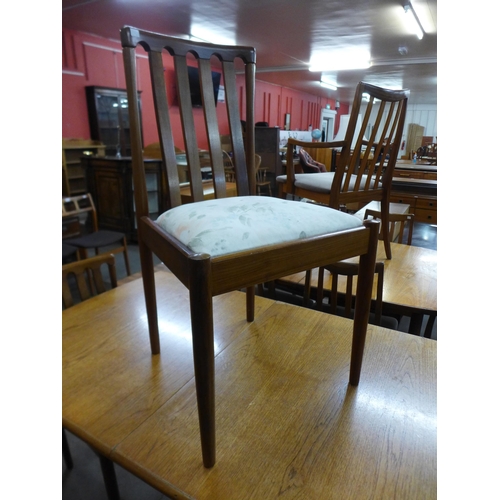 137 - A teak extending dining table and three chairs