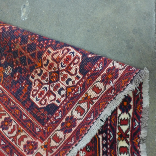 16 - An eastern red ground rug, 289 x 202cms