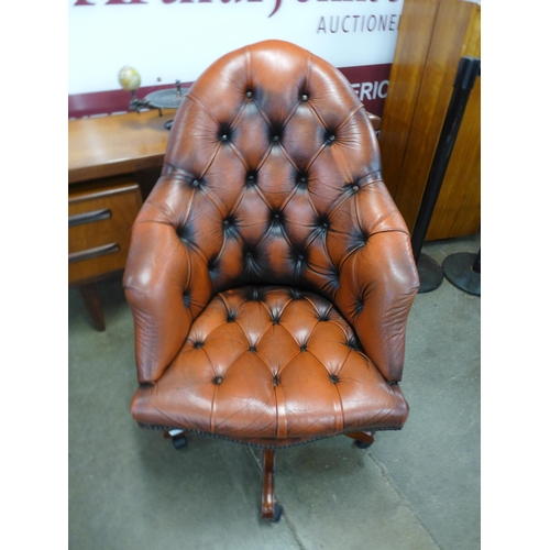 21 - A mahogany and red buttoned leather revolving desk chair