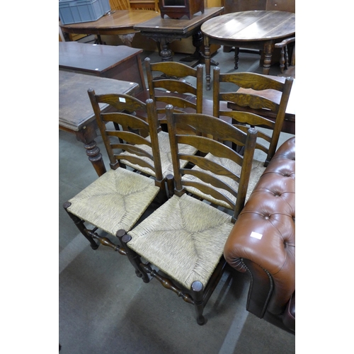 230 - A set of four oak and rush seated ladderback chairs