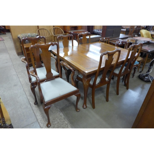 237 - A walnut draw leaf table and six chairs