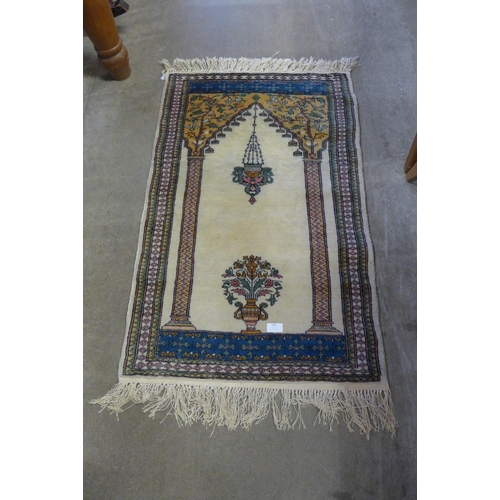 245 - A small hand knotted eastern cream ground rug