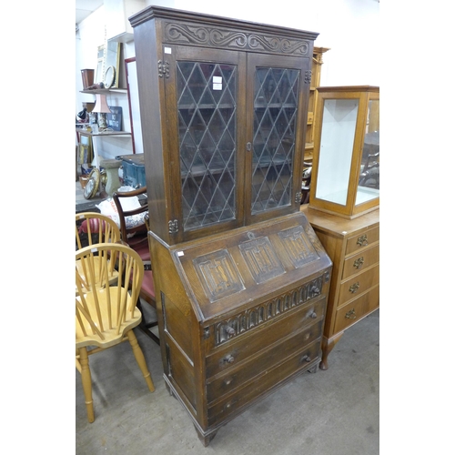 263 - A carved oak linenfold bureau bookcase