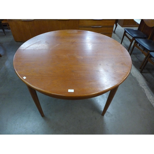 99 - A teak extending dining table