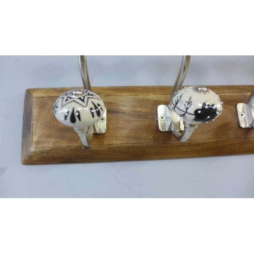 1462 - A rack of six coat hooks with black and white patterned ceramic knobs (HH565418)   #