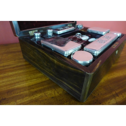 11 - A Regency coromandel and brass inlaid lady's sewing box, with silver mounted glass bottles