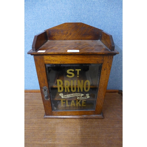 377 - A small oak table top cabinet, bearing later St. Bruno Flake painted inscription to door