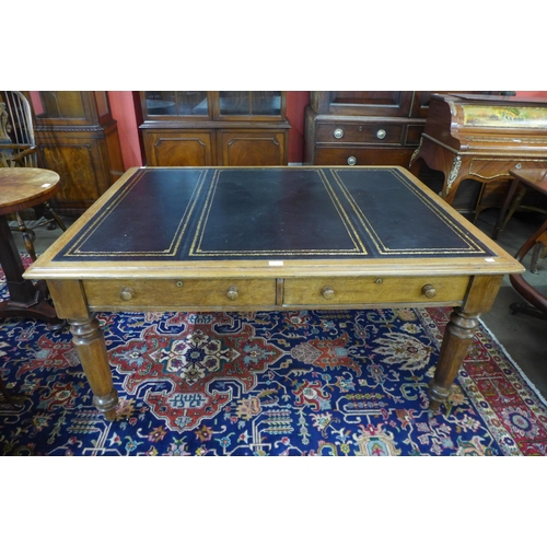 39 - A Victorian oak and black leather topped double sided four drawer library table