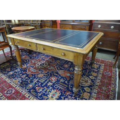 39 - A Victorian oak and black leather topped double sided four drawer library table