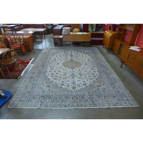 44 - A Persian hand knotted wool cream ground Kashan rug, 397 x 296cms