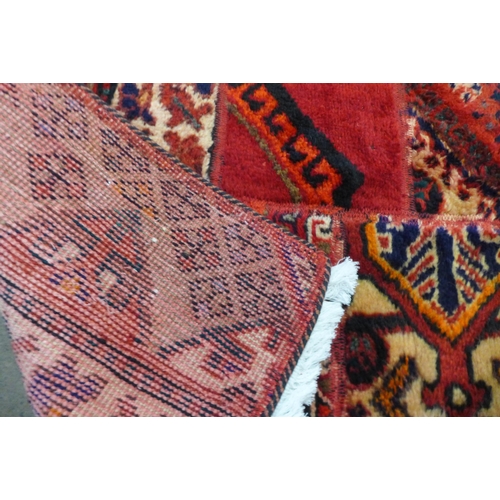 46 - A Persian hand knotted wool patchwork red ground rug