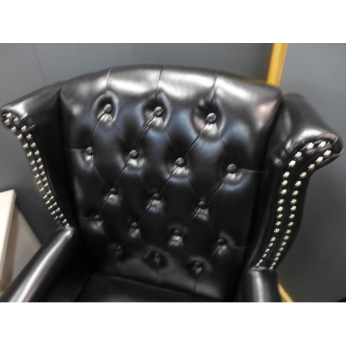 1308 - A black upholstered buttoned armchair * this lot is subject to VAT