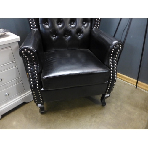 1308 - A black upholstered buttoned armchair * this lot is subject to VAT