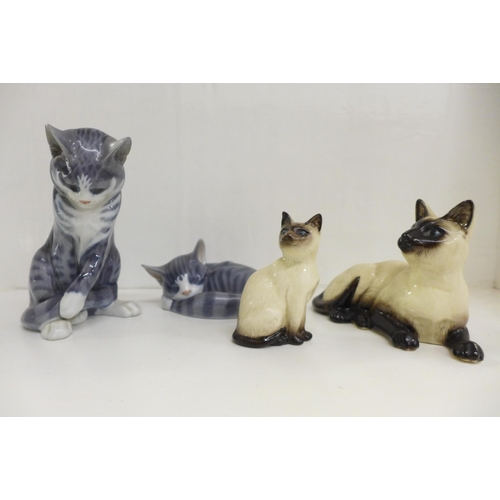 609 - Two Royal Copenhagen figures of cats, a sitting cat and a cat laying, and two Royal Doulton Siamese ... 