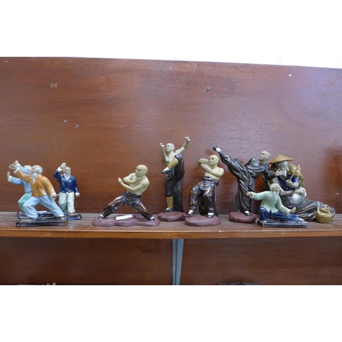 660 - A collection of nine oriental figures, Tai Chi, Martial Arts and one fisherman, one a/f