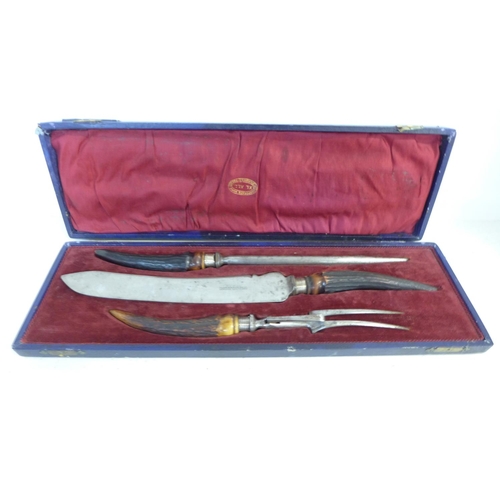 762 - A carving set with antler handles and silver ferrules