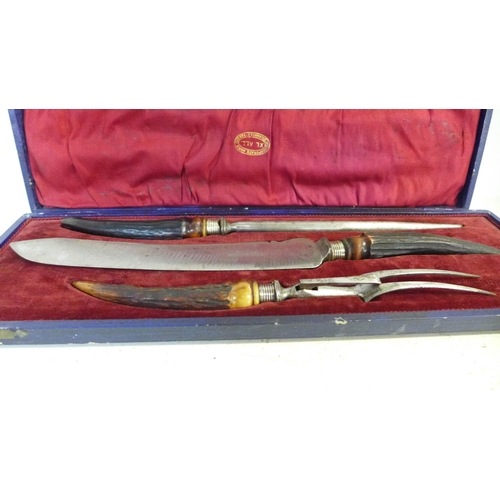 762 - A carving set with antler handles and silver ferrules