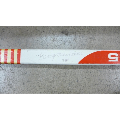 805 - A signed Koho ice hockey stick with two pucks