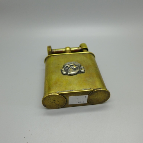 830 - An early 20th Century brass table lighter mounted with Totenkopf head, skull and crossbones or 'deat... 