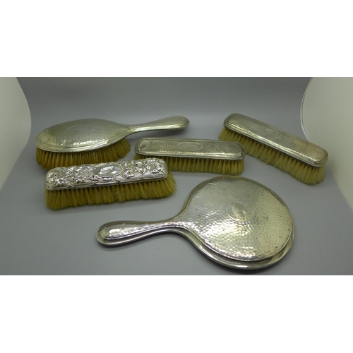 913 - A silver backed mirror and four brushes, a/f