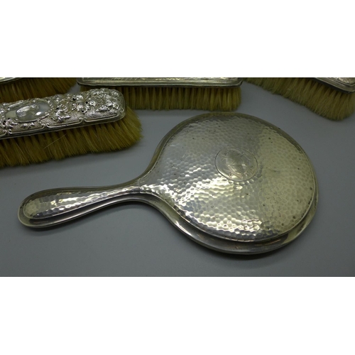 913 - A silver backed mirror and four brushes, a/f