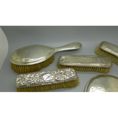 913 - A silver backed mirror and four brushes, a/f