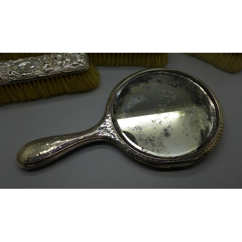 913 - A silver backed mirror and four brushes, a/f