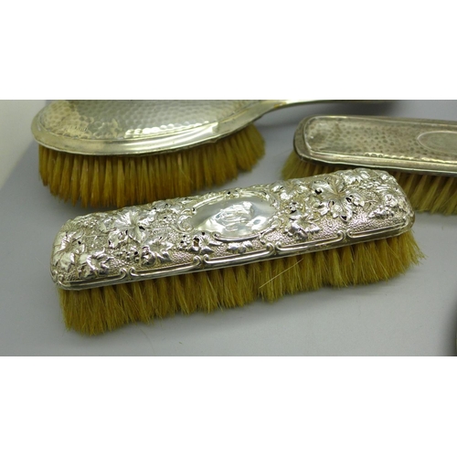 913 - A silver backed mirror and four brushes, a/f