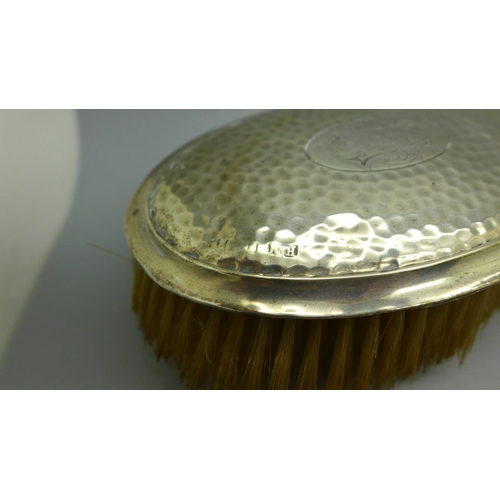 913 - A silver backed mirror and four brushes, a/f