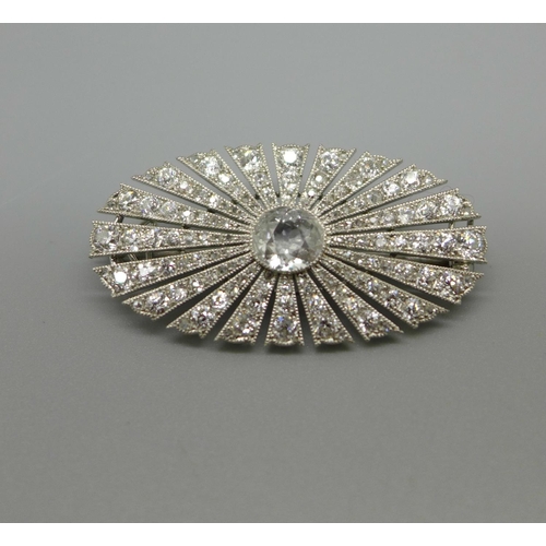 955 - An Art Deco diamond brooch, set with 126 diamonds, Millennium setting, centre stone 1ct diamond weig... 