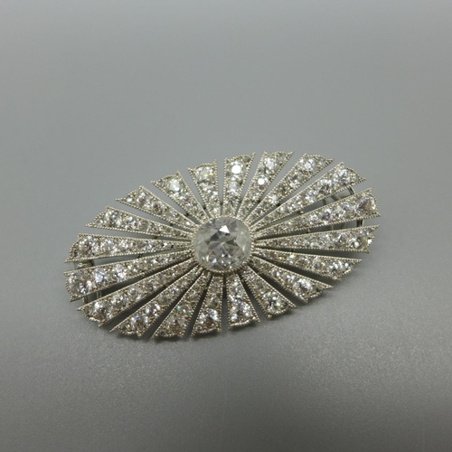 955 - An Art Deco diamond brooch, set with 126 diamonds, Millennium setting, centre stone 1ct diamond weig... 