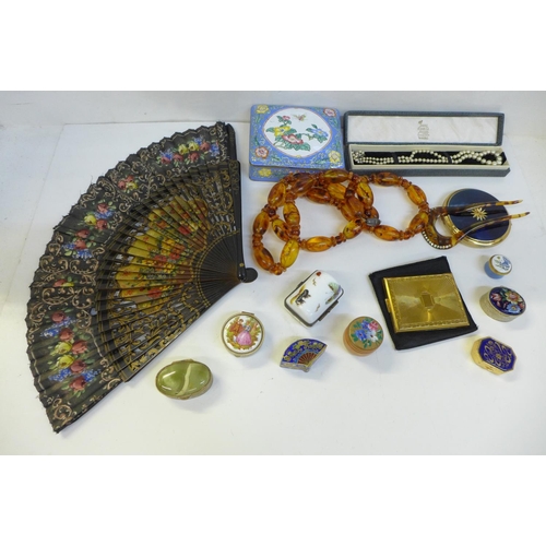 702 - Compacts, an enamel box, a string of amber coloured beads, etc.