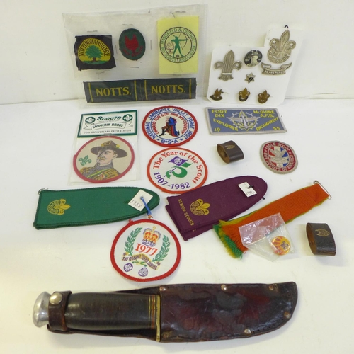 711 - A collection of Scout badges, cloth and metal, two leather woggles and a Scout knife and scabbard, m... 