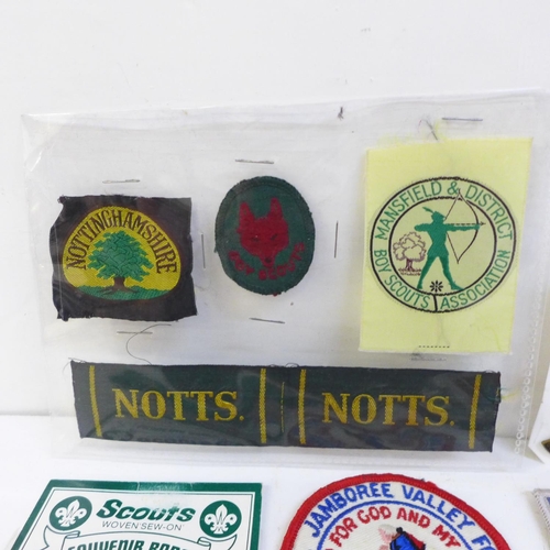 711 - A collection of Scout badges, cloth and metal, two leather woggles and a Scout knife and scabbard, m... 