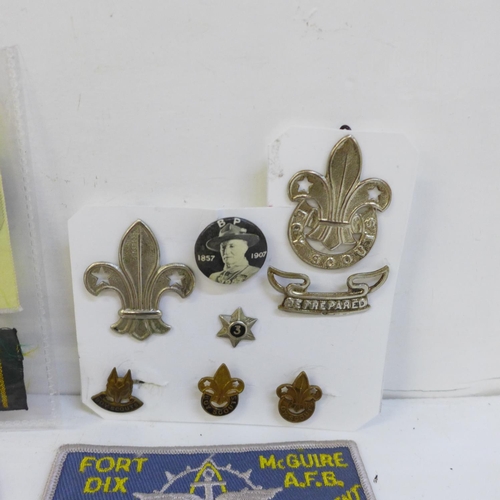 711 - A collection of Scout badges, cloth and metal, two leather woggles and a Scout knife and scabbard, m... 