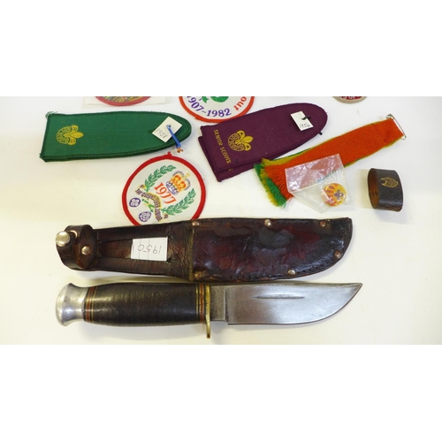 711 - A collection of Scout badges, cloth and metal, two leather woggles and a Scout knife and scabbard, m... 