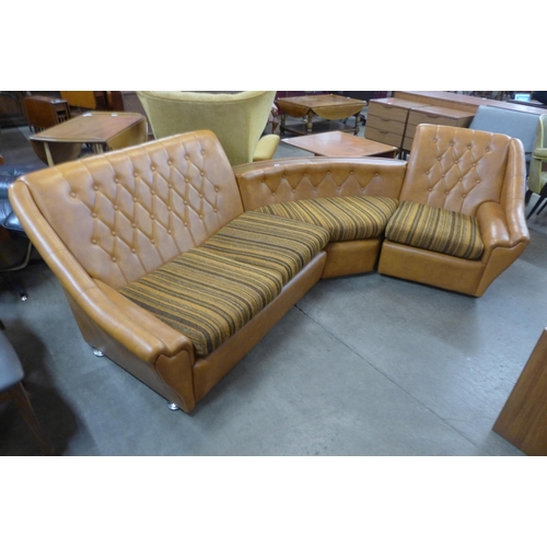 101 - A 1970's faux leather and simulated rosewood corner sofa