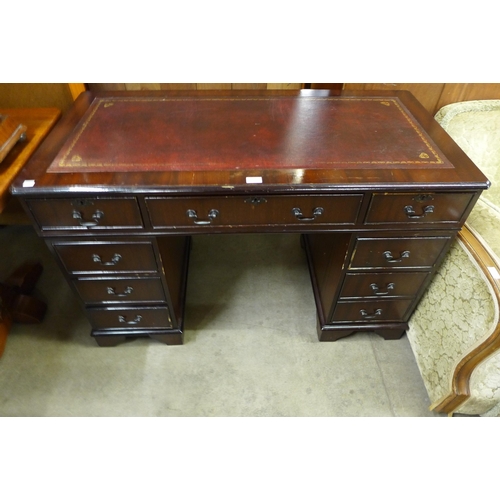 135 - A mahogany and red leather topped pedestal desk