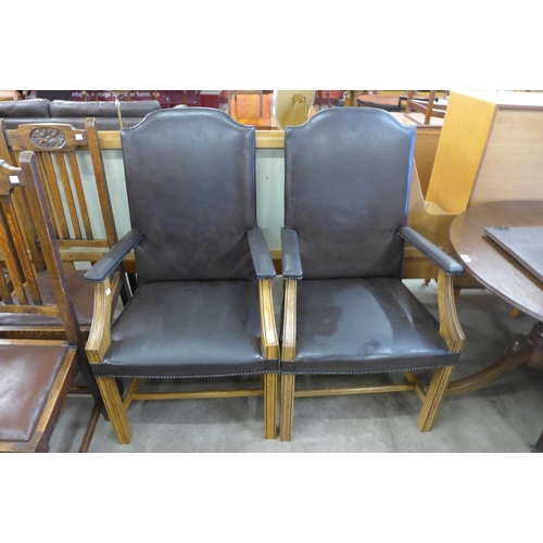 141 - A pair of Regency style oak and brown leather library chairs