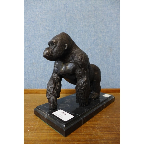 413 - A bronze figure of a gorilla, on black marble socle