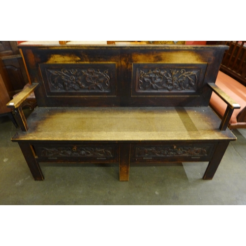 50 - An Arts and Crafts carved oak settle