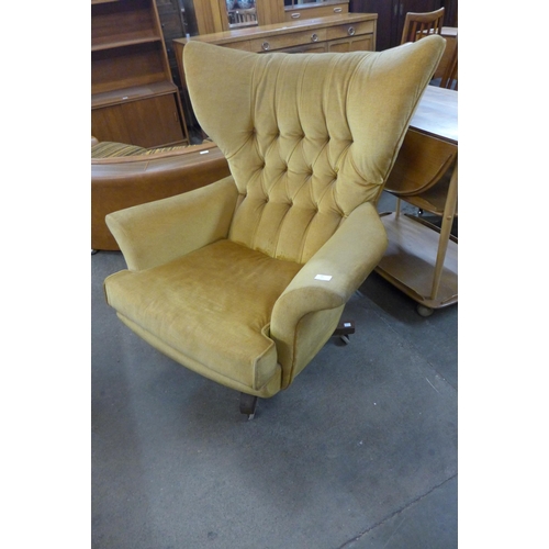 85 - A G-Plan Blofeld teak and yellow fabric revolving lounge chair, model 6250, designed by Paul Conti